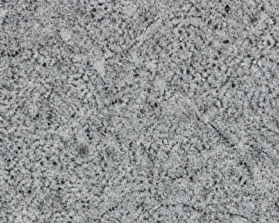 Grauer Granit mit kristalliner Struktur und feinen Sprenkeln.